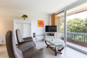 a living room with two chairs and a table at Malgré Tout 0312 in Koksijde