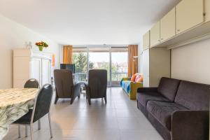 a living room with a couch and a table at Malgré Tout 0312 in Koksijde +6 photos
