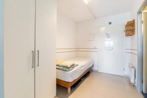 a small white room with a small bed in it at Malgré Tout 0312 in Koksijde