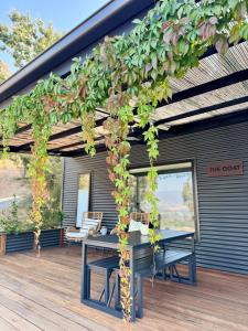 eine Pergola mit Picknicktisch auf einer Terrasse in der Unterkunft Bluestone Ridge in Whitfield