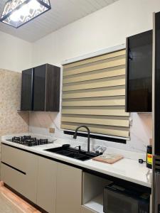 a kitchen with a sink and a stove at Serene Coastal Escapes GH in Prampram +4 photos