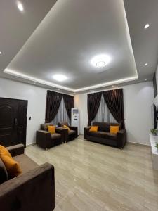 a large living room with couches and curtains at Serene Coastal Escapes GH in Prampram