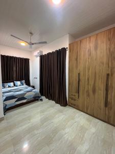 a bedroom with a bed and wooden cabinets at Serene Coastal Escapes GH in Prampram