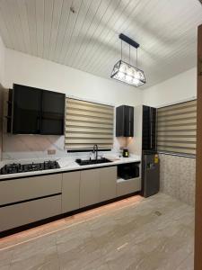 a large kitchen with white counters and a sink at Serene Coastal Escapes GH in Prampram