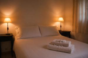 チャスコムスにあるApart Hotel Las Moraditas - a 50 metros de la Lagunaの白いベッドの上に折りたたまれたタオルが2枚置いてある。 +15枚の写真