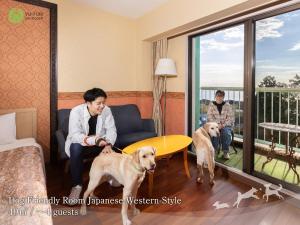 two people and two dogs in a room with a balcony at YU-FURI Izukogen in Ito