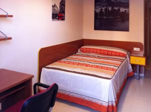 1 dormitorio con cama, mesa y escritorio en Hostal Residencia Batuecas, en Salamanca