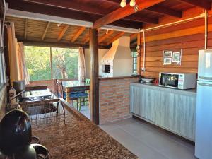 a kitchen with wooden walls and a counter top at Residencial Hibiscos - Vista Mar in Garopaba