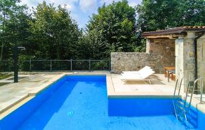 a blue swimming pool with a chair and a table at Amazing Home In Lanisce in Lanišće +25 photos