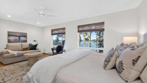 a white bedroom with a large bed and a couch at Eagles Bluff by AvantStay in Greenbank