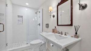 a white bathroom with a sink and a toilet at Eagles Bluff by AvantStay in Greenbank +47 photos