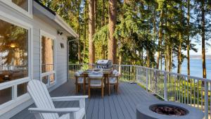 a deck with a table and chairs and a grill at Eagles Bluff by AvantStay in Greenbank