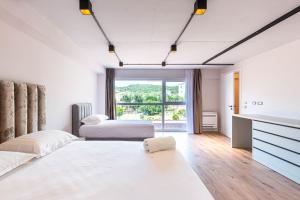 a bedroom with two beds and a large window at AMA'S Duplex 5 - Parking, Kitchen, Central in Himare