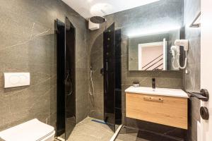 a bathroom with a shower and a sink and a toilet at AMA'S Duplex 5 - Parking, Kitchen, Central in Himare +17 photos