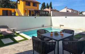 a patio with a table and chairs next to a swimming pool at Lovely Apartment In Rovinj in Rovinj +31 photos
