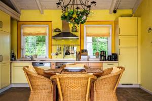 a yellow kitchen with a wooden table and chairs at Ferienhaus Kathi - Ihre Auszeit direkt am See in Jabel in Jabel +12 photos