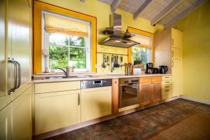 a kitchen with yellow cabinets and a sink at Ferienhaus Kathi - Ihre Auszeit direkt am See in Jabel in Jabel