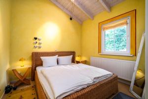 a bedroom with a bed in a room with a window at Ferienhaus Kathi - Ihre Auszeit direkt am See in Jabel in Jabel