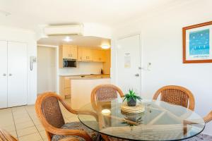 a dining room with a glass table and chairs at Ocean View Villa in Yeppoon