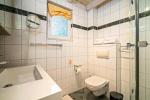 a white bathroom with a toilet and a sink at Ferienhaus Kathi - Ihre Auszeit direkt am See in Jabel in Jabel