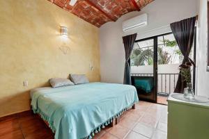 a bedroom with a bed and a large window at Casa Carmela in Sayulita