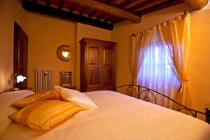 a bedroom with a bed with pillows and a window at Villa Il Seccatoio in Poggioni