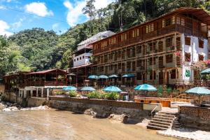 a building with blue umbrellas on a beach at Hotel Termales Espiritu Santo in Nariño