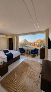 a hotel room with a bed and a large window at Leeda Pyramids View in Cairo