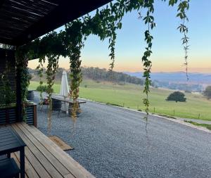 eine Veranda mit einem Tisch und Blick auf ein Feld in der Unterkunft Bluestone Ridge in Whitfield