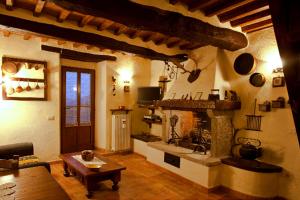 a living room with a stone fireplace and a table at Villa Il Seccatoio in Poggioni