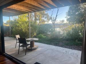 a patio with a table and chairs and a window at Your SHACK by the water in Sorell