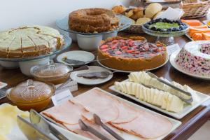 a table with many different types of cakes and pies at Pousada do Centro Búzios in Búzios