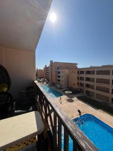 a balcony with two swimming pools on a building at شالية غرفتين بقرية ديمورا in Dawwār Muḩammad Abū Shunaynah