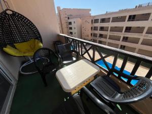 a balcony with a table and chairs on a building at شالية غرفتين بقرية ديمورا in Dawwār Muḩammad Abū Shunaynah