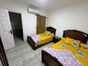 a bedroom with two beds and a door to a room at شالية غرفتين بقرية ديمورا in Dawwār Muḩammad Abū Shunaynah +11 photos
