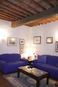 uma sala de estar com dois sofás azuis e uma mesa de centro em Abitare Il Borgo em Castagneto Carducci