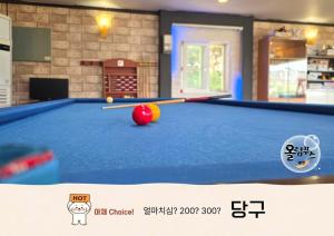 a pool table with a ball and cues on it at Hoengseong Olympus Pension in Hoengseong