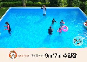 a group of people playing in a swimming pool at Hoengseong Olympus Pension in Hoengseong