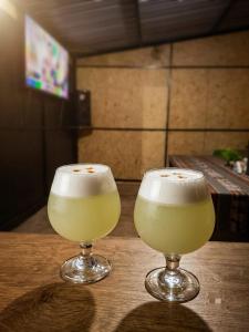 two glasses of yellow drinks sitting on a table at Refugio Salkantay collpapampa in Colcapampa
