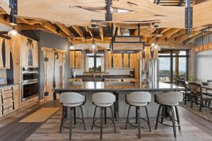 a kitchen with wooden ceilings and a large island with stools at The Bald Doe in Sturgis