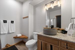a bathroom with a sink and a toilet and a mirror at The Bald Doe in Sturgis +53 photos