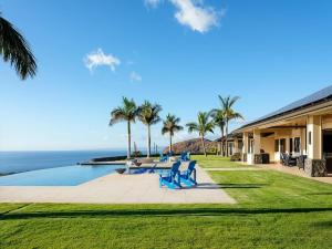 a resort with a swimming pool and palm trees at Villa with pool extraordinary view in Lahaina in Lahaina