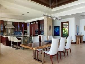 a kitchen and dining room with a wooden table and white chairs at Villa with pool extraordinary view in Lahaina in Lahaina