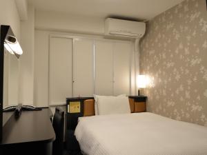 a hotel room with a bed and a desk and a bed sidx sidx at APA Hotel Saitama Ageo-Ekimae in Ageo