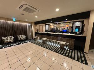 a hotel lobby with a bar and two chairs at APA Hotel Saitama Ageo-Ekimae in Ageo +37 photos