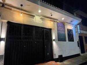 a building with a black door on a street at night at Casa hotel Manhattan L&P in Choachí