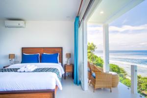 a bedroom with a bed and a view of the ocean at NEW! 3BR Ocean View, Infinity Pool, Villa Helios in Sampalan +49 photos
