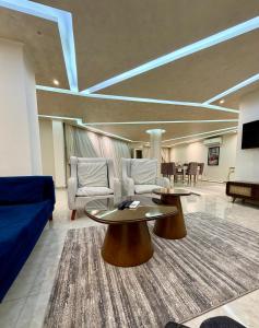 a living room with two tables and a blue couch at برج زيزينيا in Port Said
