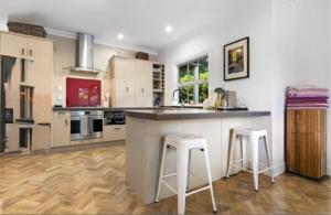 a kitchen with a counter and two stools at Wood Street Haven in Greytown +4 photos