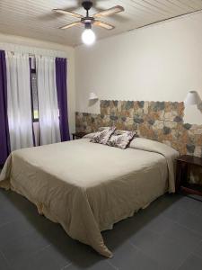 a bedroom with a large bed with a stone wall at Hotel Mirage Spa in Carhué